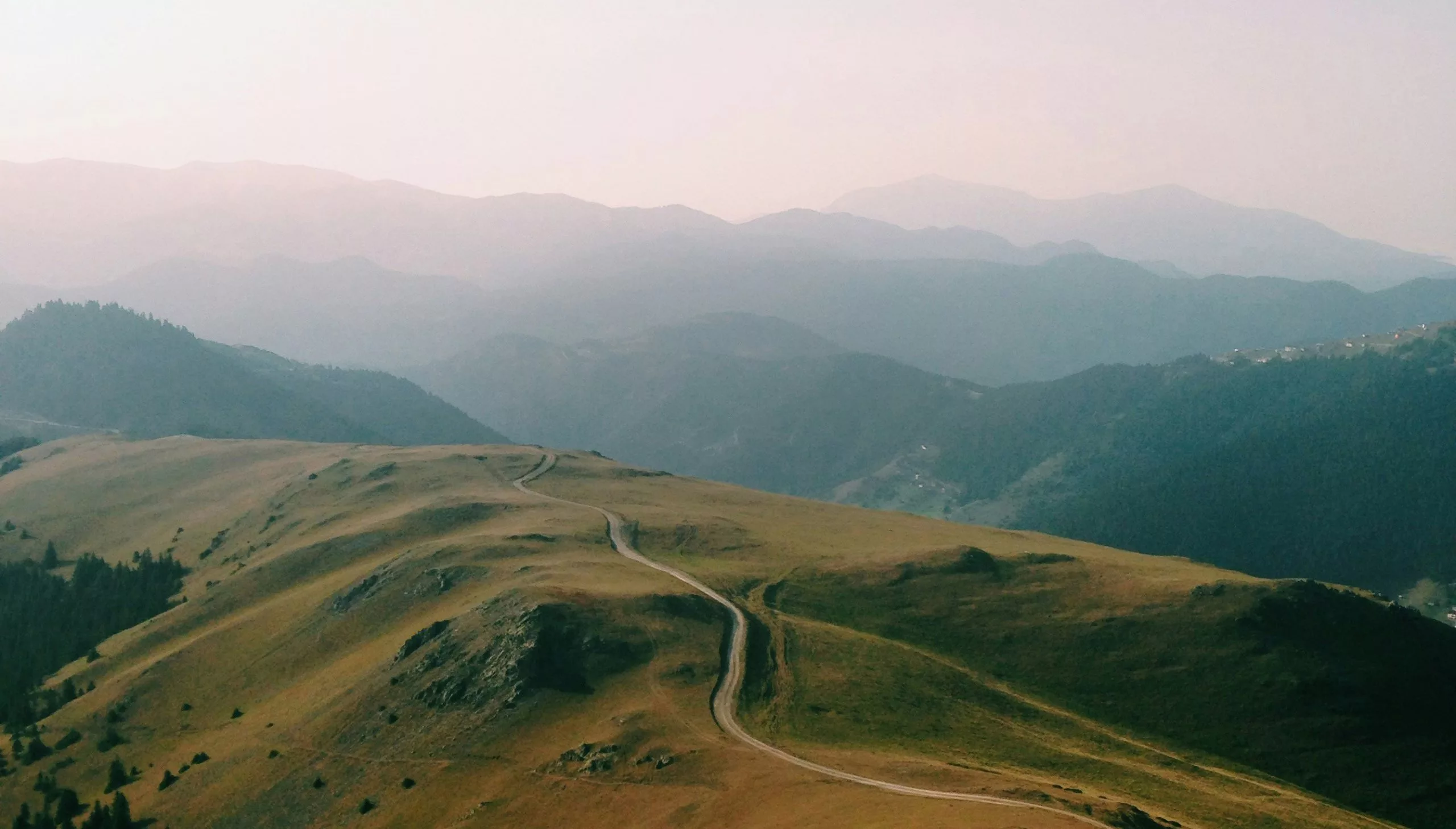 A dirt road stretching along a high mountain ridge, symbolizing perspective, clarity, and moving forward through life's challenges.